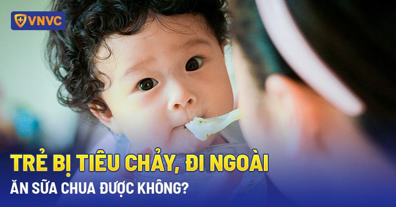 Em bé đáng yêu đang cầm chai sữa chua uống probi, thể hiện sự thích thú và khỏe mạnh đường tiêu hóa