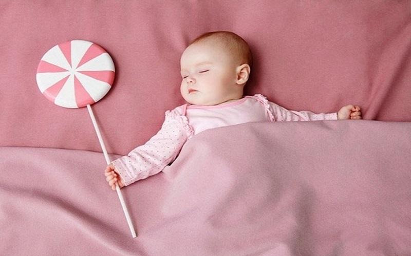 Hình ảnh một người mẹ đang nhẹ nhàng quấn tã cho trẻ sơ sinh hoặc bế rung/vỗ về bé, minh họa các kỹ thuật xoa dịu khoa học giúp trẻ con hết khóc đêm.