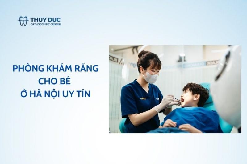 Một người phụ nữ trẻ đang làm việc trên laptop tại bàn làm việc ở nhà, đồng thời quan sát đứa con đang vui chơi ở khu vực được thiết kế riêng cho bé trong phòng khách. Ánh sáng tự nhiên tràn ngập căn phòng, tạo cảm giác ấm cúng, thư thái.