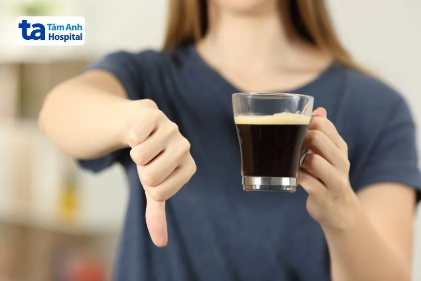 Người phụ nữ đang uống cà phê và nhìn ra ngoài cửa sổ