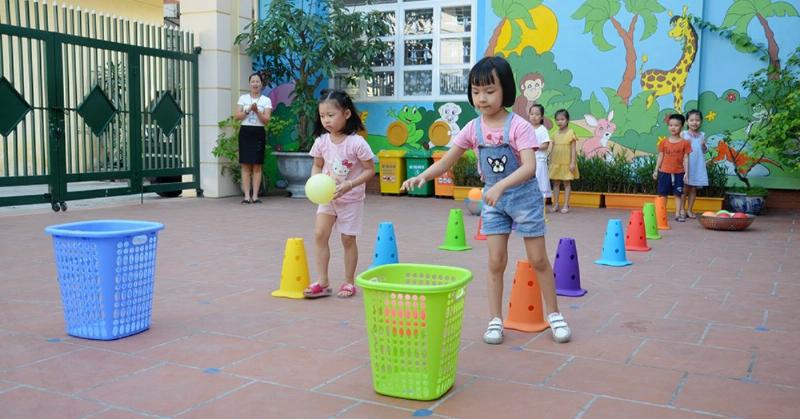 Người mẹ đang tương tác vui vẻ với con trai chơi xe ô tô chòi chân, thể hiện sự gắn kết gia đình