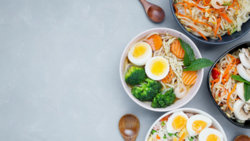 Một gia đình Việt Nam đang cùng nhau ăn một bữa ăn lành mạnh với nhiều thực phẩm giàu canxi (rau lá xanh, cá nhỏ, sản phẩm từ sữa). Bối cảnh vui vẻ, ấm cúng, thể hiện lối sống khoa học cho trẻ phát triển chiều cao.
