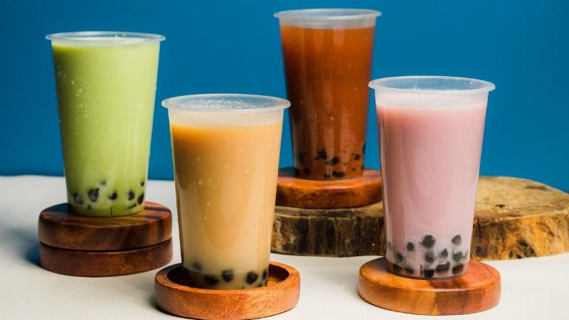 Mẹ bầu hoặc mẹ bỉm sữa đang thư giãn, thưởng thức đồ uống lành mạnh bên cạnh em bé