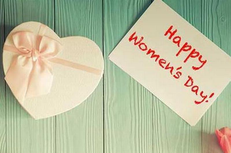 Hình ảnh một người phụ nữ trưởng thành hạnh phúc nhận quà và lời chúc mừng 8/3 từ chồng và con, gia đình quây quần ấm áp.