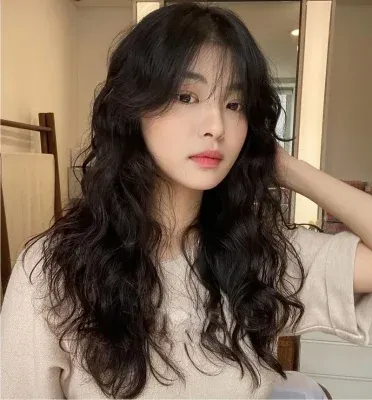 Người phụ nữ với tóc xoăn nhỏ bồng bềnh, che khuyết điểm mặt tròn hiệu quả
