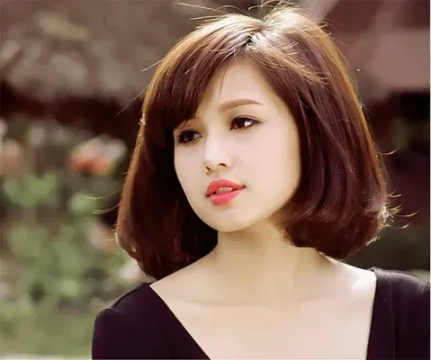 Kiểu tóc ngắn uốn cụp, mái dài lệch phù hợp với mặt tròn béo